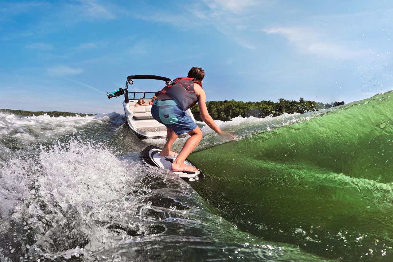 Family wakesurfing astern of an SDX 230 Surf