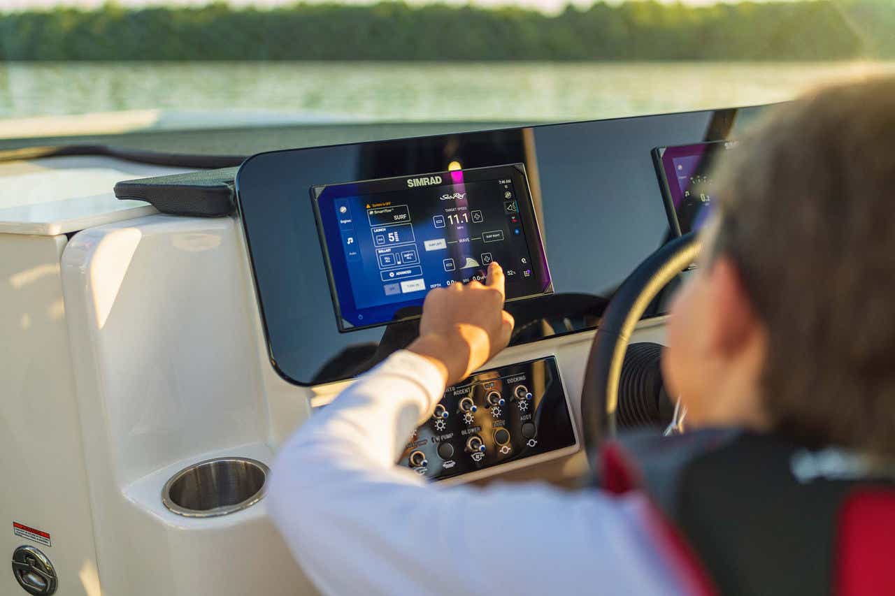 Kid at the SDX 230 Surf helm reviewing the dash